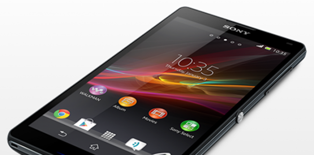 Smartphone Sony Xperia ZQ de cor preta exibindo a tela inicial com o widget de relógio clássico da Sony.