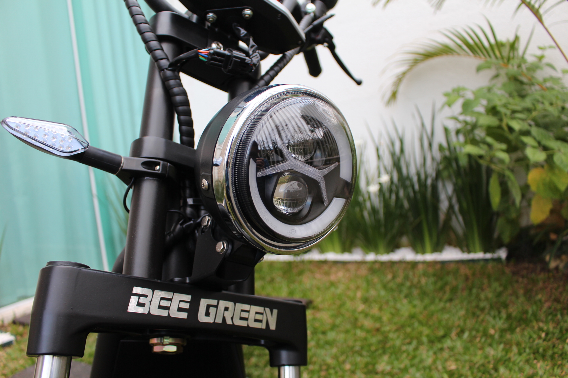Close do farol redondo de LED da scooter elétrica Bee Green Sport Plus.