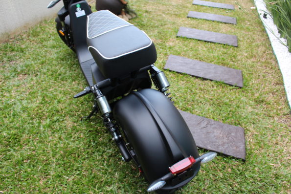 Vista superior da parte traseira da scooter, mostrando o banco e o pneu largo.
