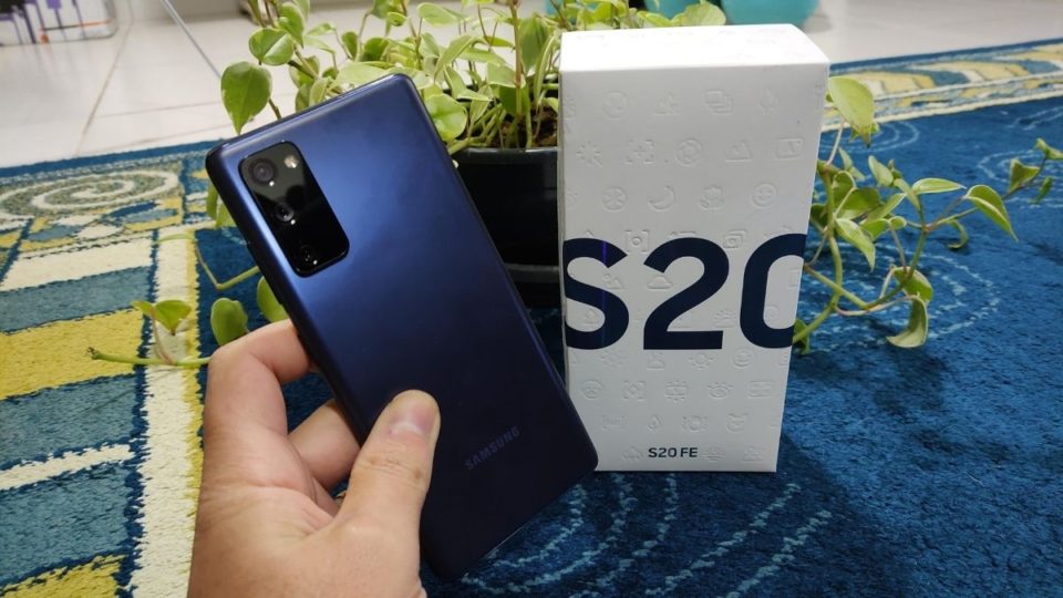 Smartphone Samsung Galaxy S20 FE azul ao lado de sua caixa, destacando o design traseiro.