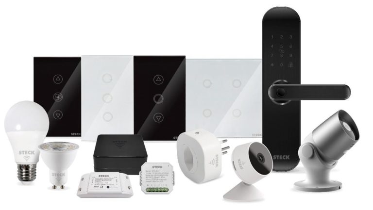 Exibição de diversos produtos da linha Smarteck da Steck sobre um fundo branco, incluindo lâmpadas LED inteligentes, interruptores touch, mini-interruptor interno, controle universal infravermelho e câmeras de segurança Wi-Fi.