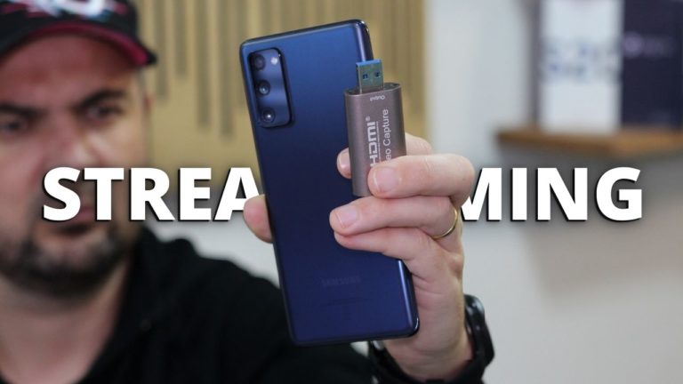 Visão superior de um smartphone Samsung Galaxy e uma placa de captura USB prateada.