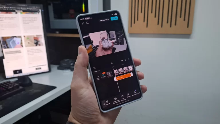 Pessoa segurando um smartphone e editando um vídeo no aplicativo CapCut, com a interface da linha do tempo visível na tela.