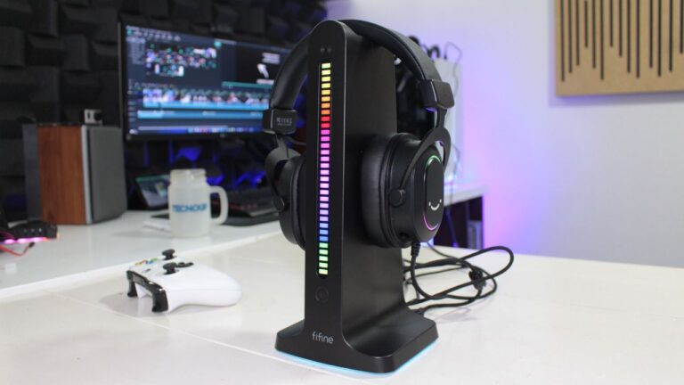 Suporte para headset Fifine AmpliGame S3 com iluminação RGB reativa ao som em um setup gamer.