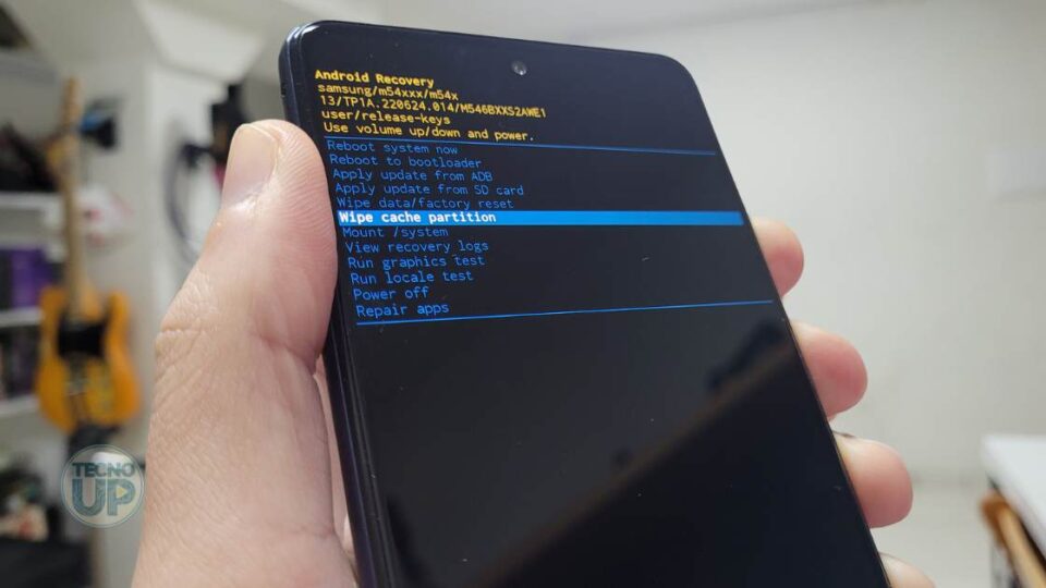 Imagem mostra mão segurando celular para fazer o procedimendo de wipe cache partition.