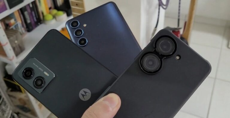 Close em três smartphones diferentes sendo segurados pela mão, destacando as lentes das câmeras traseiras para exemplificar o uso de HDR.