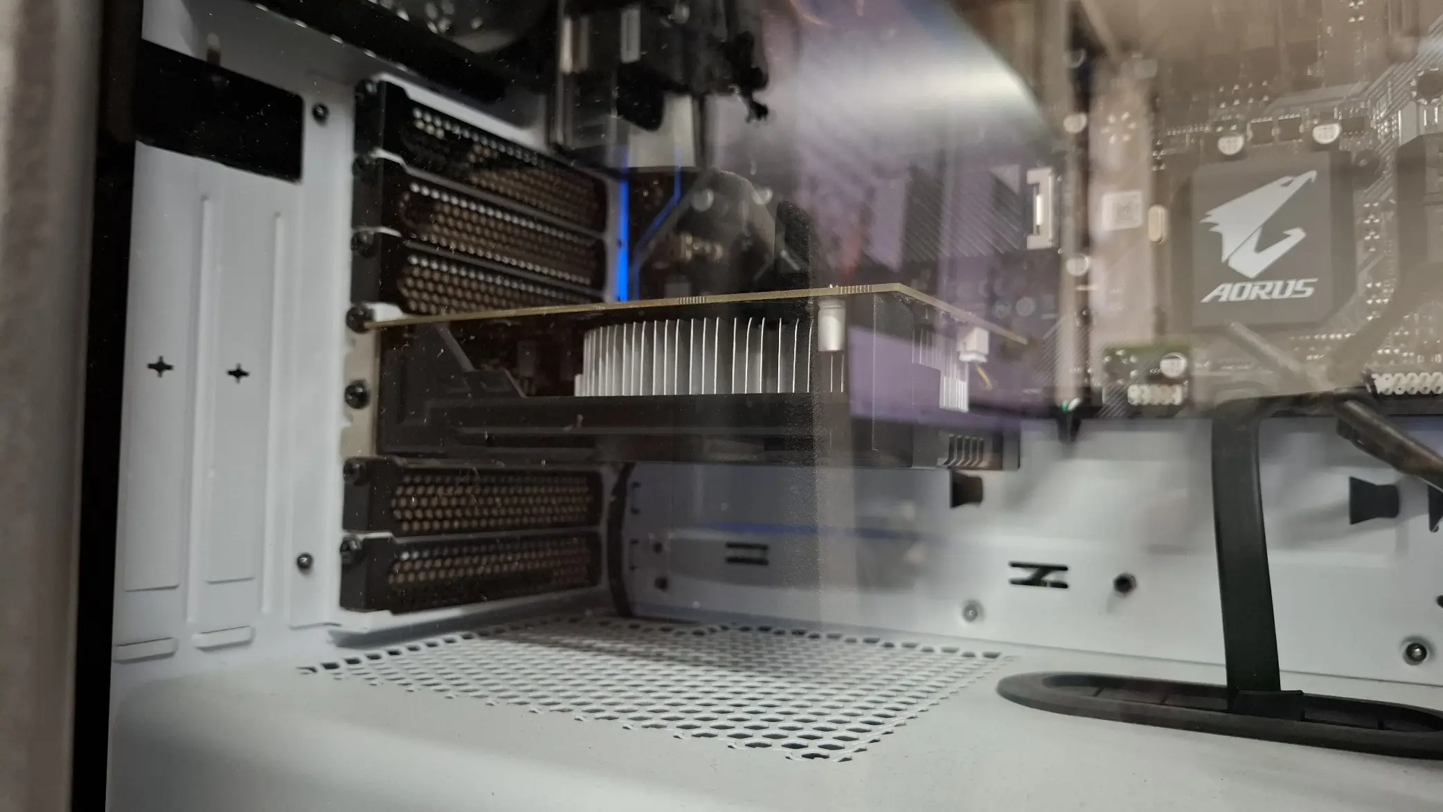 Visão interna de um gabinete de PC com uma placa de vídeo AMD RX 550 instalada em uma placa-mãe Aorus, ilustrando um setup de testes para resolver problemas de crash.
