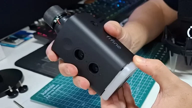 Microfone dinâmico Fifine Ampligame AM8 sendo segurado para mostrar detalhes do design e acabamento.