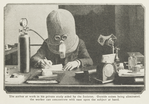 Foto histórica em preto e branco de um homem usando "The Isolator", um capacete de metal bizarro de 1925 com pequenas fendas para os olhos e um tubo de oxigênio acoplado.