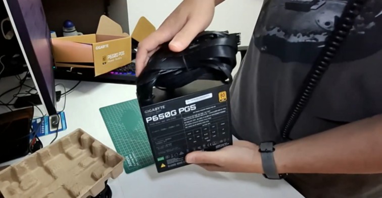 Imagem mostra uma pessoa segurando uma fonte de PC modelo Gigabyte P650G PG5 80 Plus Gold.