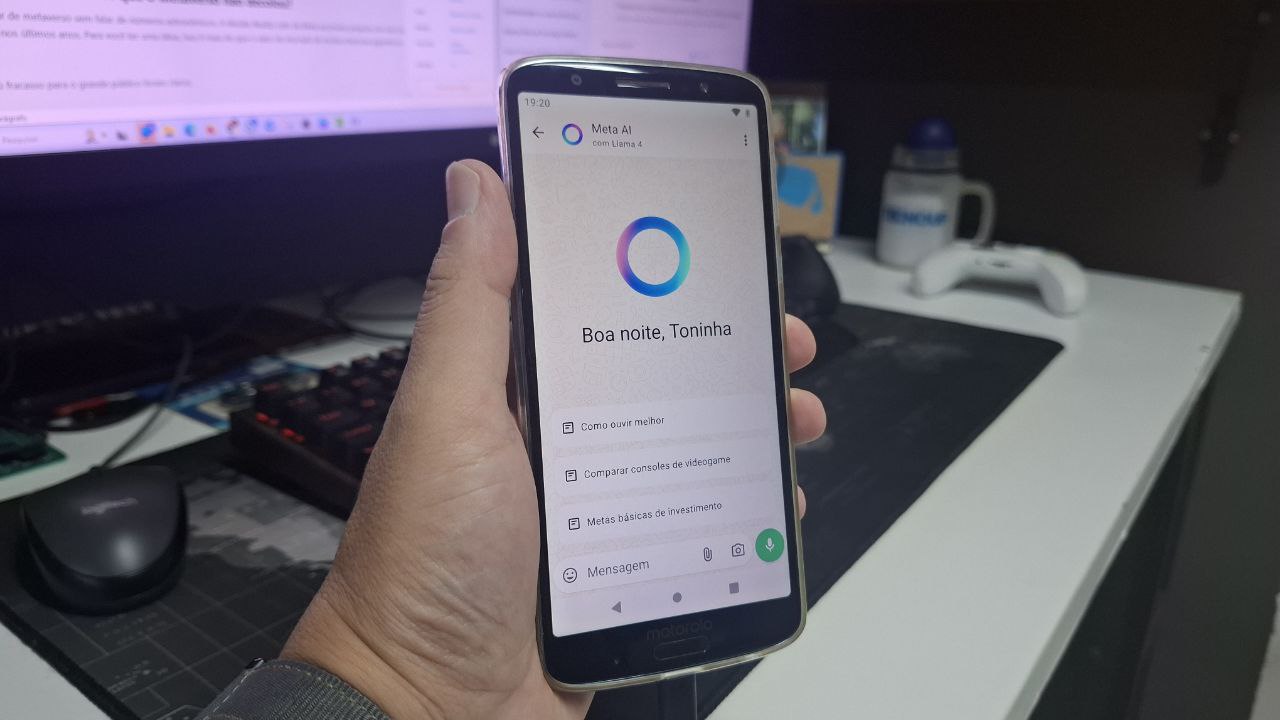 Imagem mostra uma mão segurando um celular com o App Meta AI aberto no WhatsApp.
