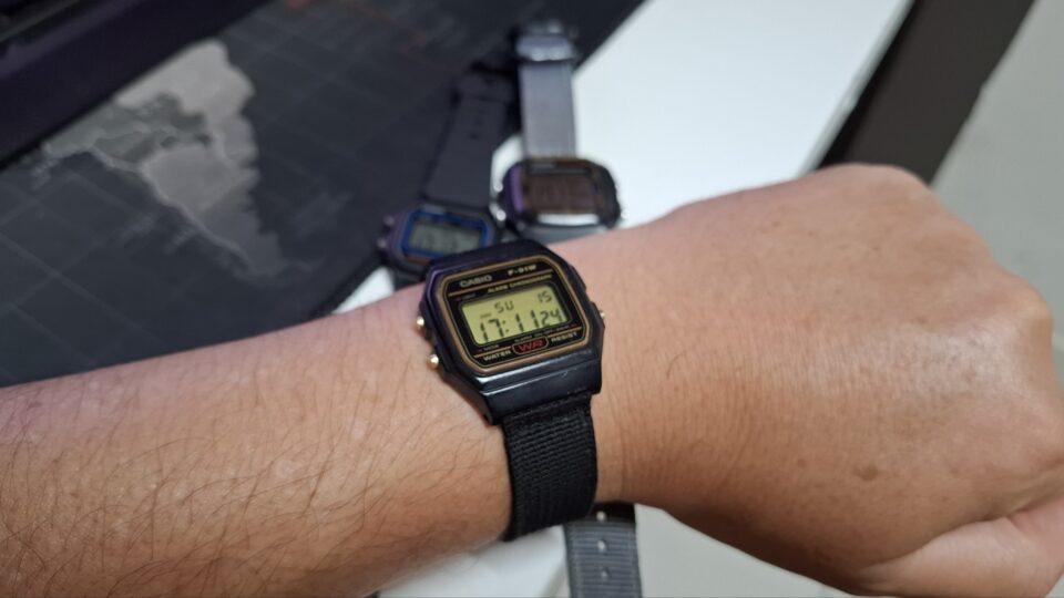 Pulso masculino usando um relógio digital clássico Casio F-91W preto, simbolizando a desconexão de notificações de smartwatches.