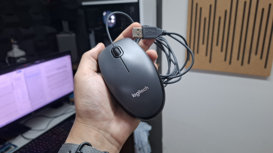 Mouse com fio Logitech M90 preto sobre uma mesa de escritório
