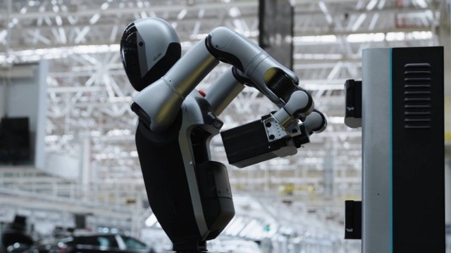Robô humanoide da empresa UBTECH realizando a troca automática de sua própria bateria em uma estação de recarga.