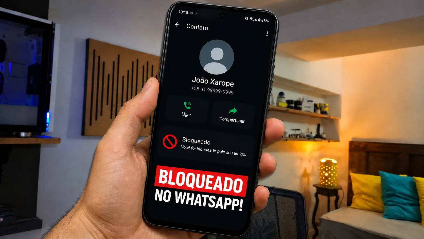 Mão segurando um celular exibindo a tela de chamada do WhatsApp com o texto Bloqueado no WhatsApp.