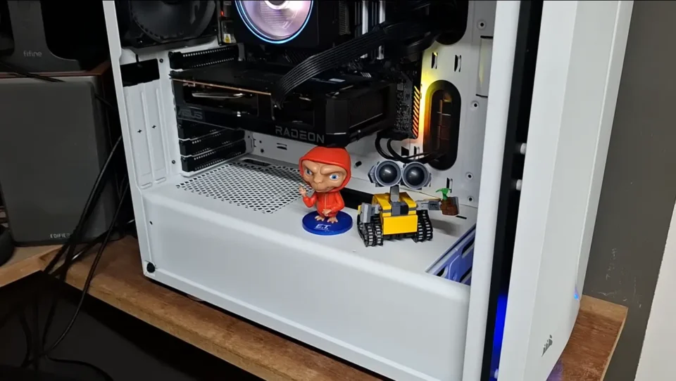 Mini robô WALL-E feito de blocos de montar decorando a parte interna de um gabinete de computador branco.