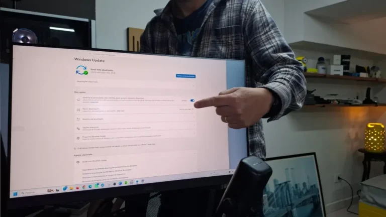 Alexandre do TecnoUp apontando para a tela do monitor mostrando as configurações e otimizações de memória do Windows 11 para PCs com 8GB de RAM.
